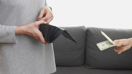 Teenager asking his mother for money. Mother couts money in her wallet and give money to her son. Woman hand giving kid some dollar bill, pocket money