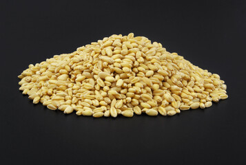 Heap of wheat grains on black background