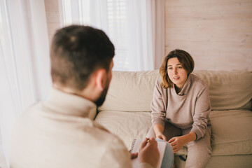 Fototapeta premium Young woman patient having consultation with psychotherapist in office. Medical mental help and support.