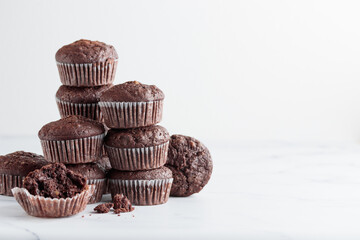 Pile of chocolate muffins on a white background