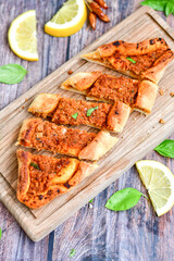  Traditional Turkish cuisine. Baked Pide dish with minced  beef, tomatoes and  herbs on  wooden background.  Turkish pizza pide