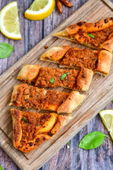  Traditional Turkish cuisine. Baked Pide dish with minced  beef, tomatoes and  herbs on  wooden background.  Turkish pizza pide