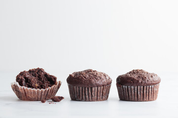 The row of chocolate muffins on a white table
