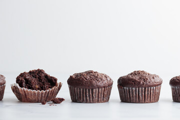 The row of chocolate muffins on a white table