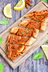  Traditional Turkish cuisine. Baked Pide dish with minced  beef, tomatoes and  herbs on  wooden background.  Turkish pizza pide