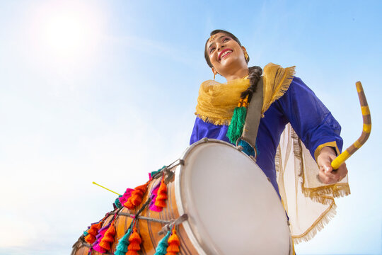 Portrait of Sikh woman playing drum during Baisakhi celebration