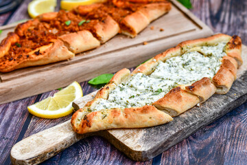  Traditional Turkish cuisine. Baked Pide dish with minced  beef, tomatoes and cheese on  wooden background.  Turkish pizza pide