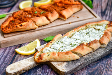  Traditional Turkish cuisine. Baked Pide dish with minced  beef, tomatoes and cheese on  wooden background.  Turkish pizza pide