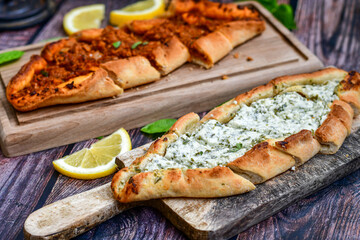  Traditional Turkish cuisine. Baked Pide dish with minced  beef, tomatoes and cheese on  wooden background.  Turkish pizza pide