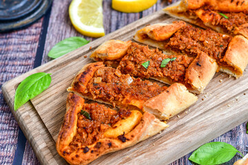  Traditional Turkish cuisine. Baked Pide dish with minced  beef, tomatoes and cheese on  wooden background.  Turkish pizza pide