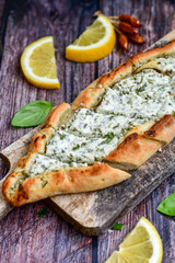  Traditional Turkish cuisine. Baked Pide dish with minced  beef, tomatoes and cheese on  wooden background.  Turkish pizza pide