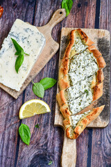  Traditional Turkish cuisine. Baked Pide dish with  cheese on  wooden background.  Turkish pizza pide