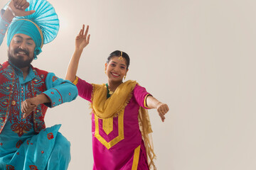 Sikh couple performing bhangra together during Baisakhi celebration