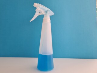 Spray bottle with blue disinfectant liquid closeup