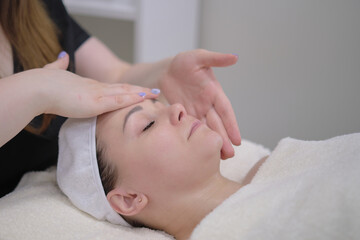 Fototapeta na wymiar beauty therapist therapist doing cosmetic procedure. Calm patient woman undergoing the cosmetic facial massage procedures for rejuvenation skin face
