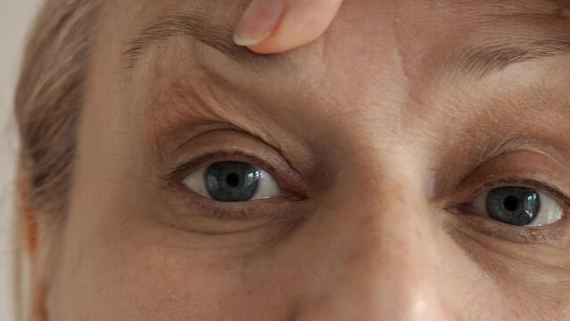 Close-up of a mature woman's eyes, she is frustrated with wrinkles on her forehead between the eyebrows