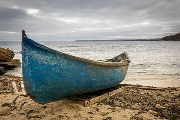 Wooden fishing boat on the beach. Stormy sky