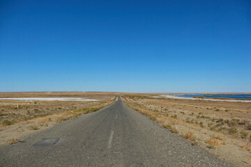 Fototapeta na wymiar The road along the desert area of the Aral region
