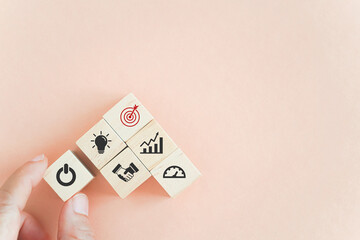 hand holding start button icon on wooden cube block with other business sign on pastel background and copy space for launch new project, growth business, restart, begin progress