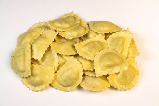 Tasty raw ravioli with flour and spinach on white background, process of making italian ravioli, High quality photo