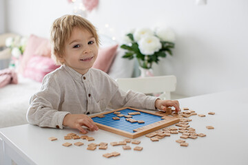 Preschool child, cute blond boy, playing with wooden numbers