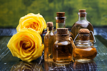 Rose oil in a glass bottles and roses close up