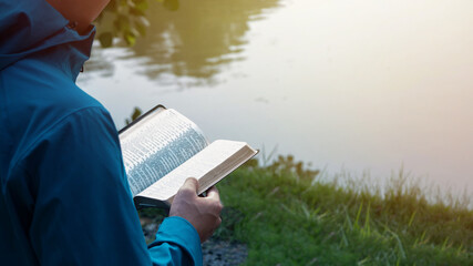 Man Reading Bible By Lake
