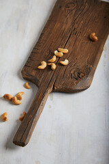Cashews on an old board on a cement textured background. With place for text and image