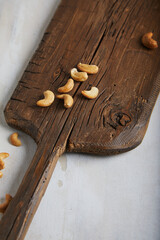 Cashews on an old board on a cement textured background. With place for text and image