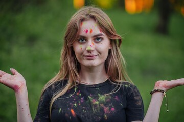 Young funny girl posing with colored powder on her face.