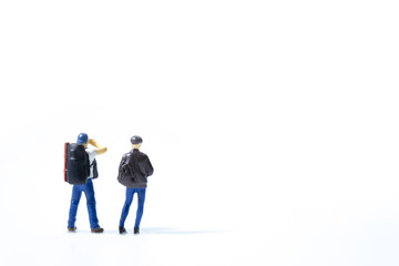 Two miniature traveler standing and looking for something on white background.