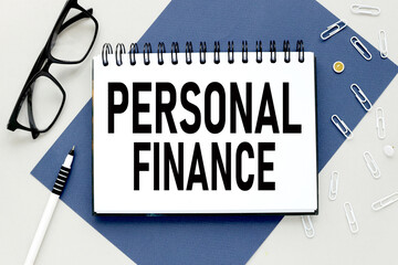 Personal Finance text on open notepad on gray and blue background