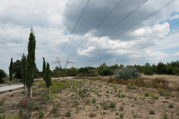 Fototapeta na wymiar Un ligne electrique a haute tension est vue dans le paysage sec de la provence pour representer l'energie et l'electricité 