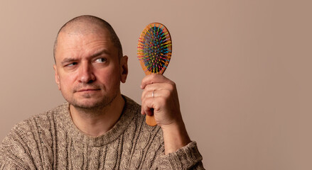 Funny humorous portrait of bald man with comb