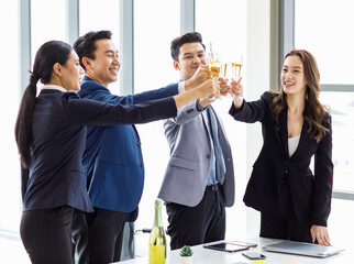 Top view shot Asian happy cheerful professional successful businessman and businesswoman in formal business suit standing smiling holding tall champagne glass toasting celebrating cheers together