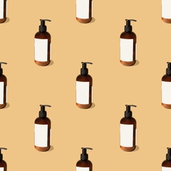 Seamless pattern of mock-ups of unmarked amber bottles with dispenser for soap, shampoo, creams. Cosmetic container close-up with sharp shadows from sunlight on beige background. Flat lay