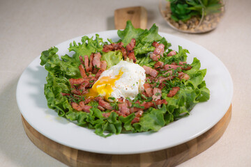 Recipe for poached egg cut with a knife, bacon and salad, High quality photo