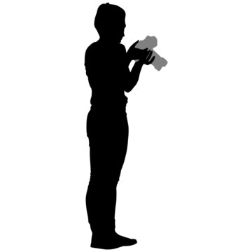 Black silhouette of girl in trousers with short haircut with camera in her hands