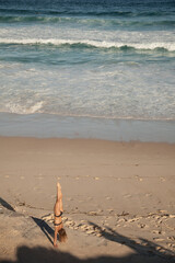 Fototapeta na wymiar Handstand pose by woman on the beach in Sydney