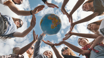 Earth conservation concept. 11 girls surround the rotating earth globe with their palms hands.