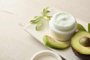 Fototapeta na wymiar Avocado moisturizing cream for skin care on white table elevated