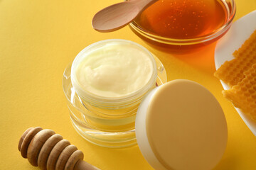 Moisturizing skin care cream with honey extracts on yellow detail