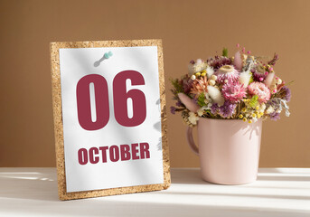 october 6. 6th day of month, calendar date.Bouquet of dead wood in pink mug on desktop.Cork board with calendar sheet on white-beige background. Concept of day of year, time planner, autumn month