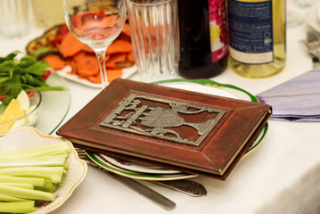 Naklejka na ściany i meble Table with Passover Haggadah and traditional food that is eaten in the Passover Seder. Seder Plate and Passover Haggadah Prepare to Pesach Seder.