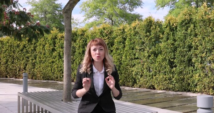 beautiful young woman journalist tells news. a lady's business in a park on the street. reporting. TV