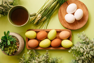 Organic eggs next to flowers and tea on a wooden table. Concept of breakfast at Easter	