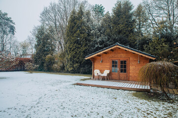 Nice wooden hut in a garden with snow. Garden shed with chairs in winter. Winter mood. Drinking tea...