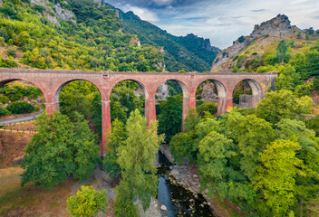 View from flying drone of ancient bridge across the Devil's Throat Gorge, San Severino village...
