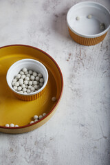 Baking balls in a baking dishes on light rust textured background. Copy space.