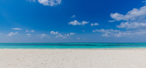 Closeup sandy beach waves and blue summer sky. Panoramic beach landscape. Empty tropical beach and seascape, horizon. Bright blue sky, soft sand, calmness, tranquil seaside relaxing sunlight, summer 
